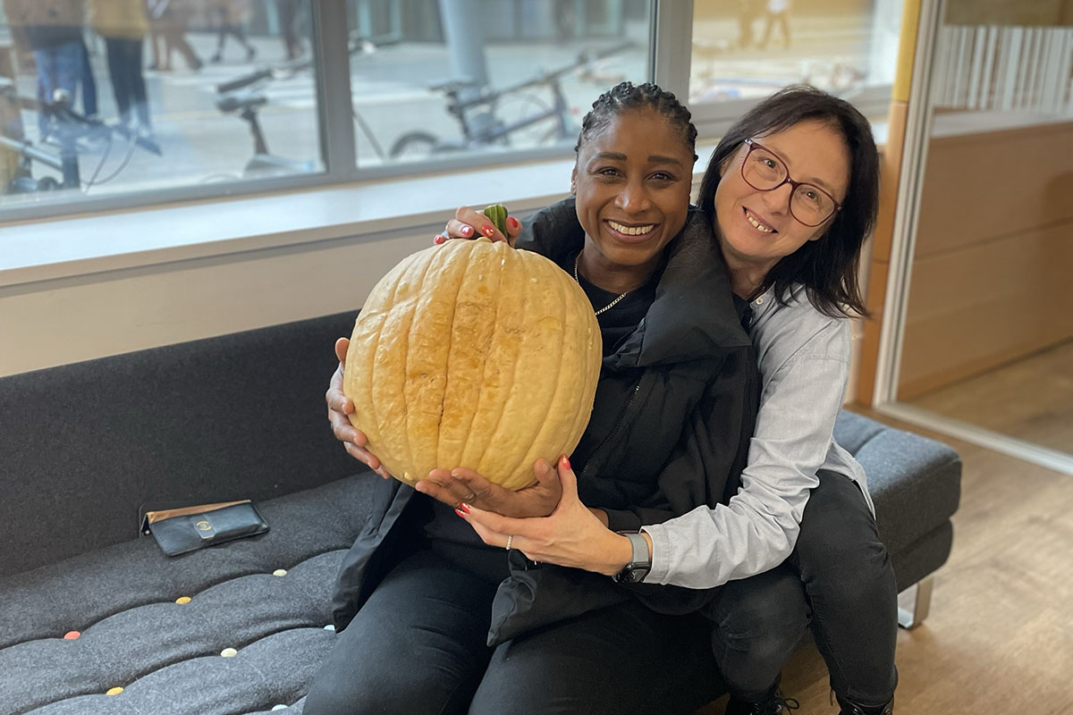 two women hugging a pumpkin